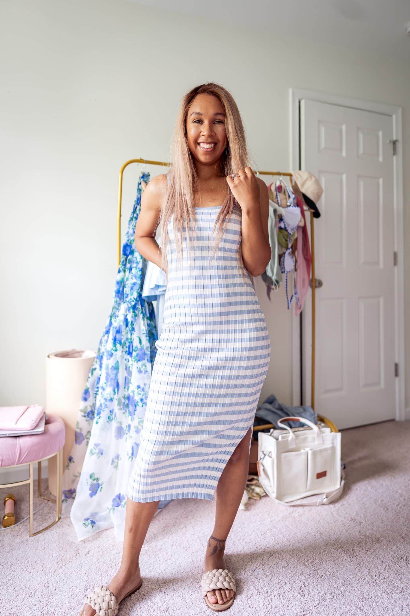 A woman wearing a striped ribbed knit midi dress, a versatile summer wardrobe essential for moms.